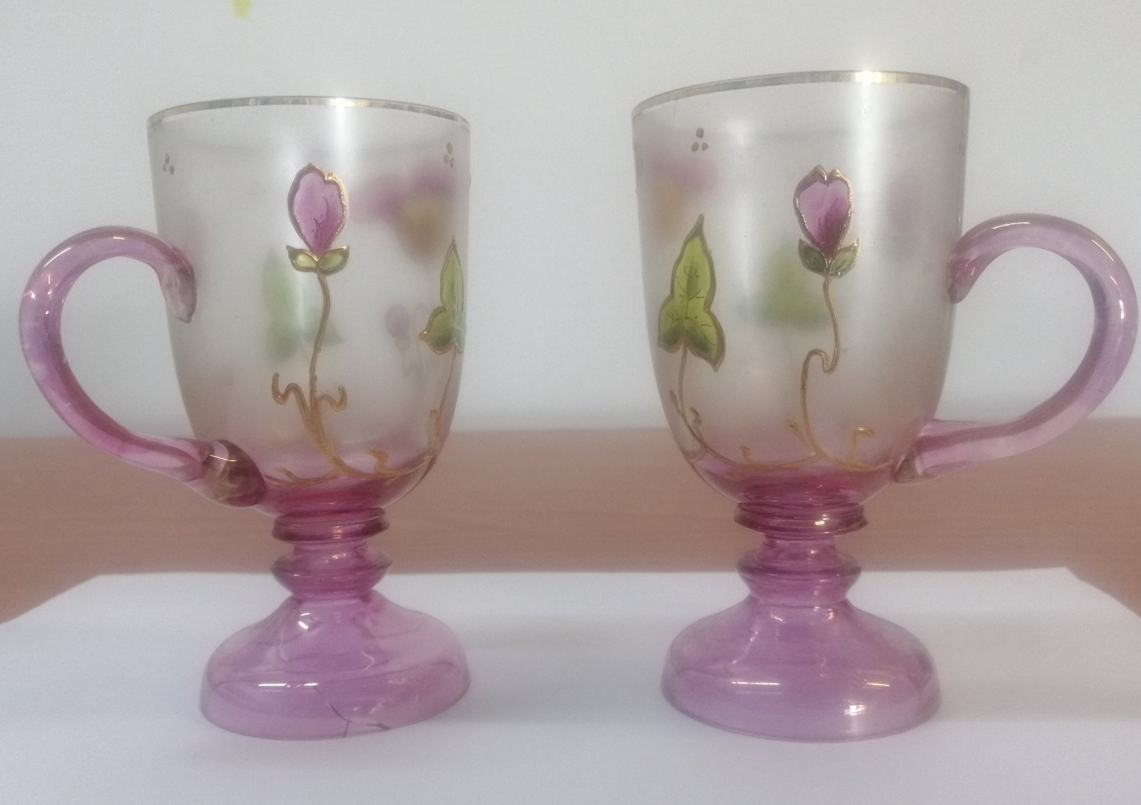 Duas xícaras roxas com flores pintadas nelas
