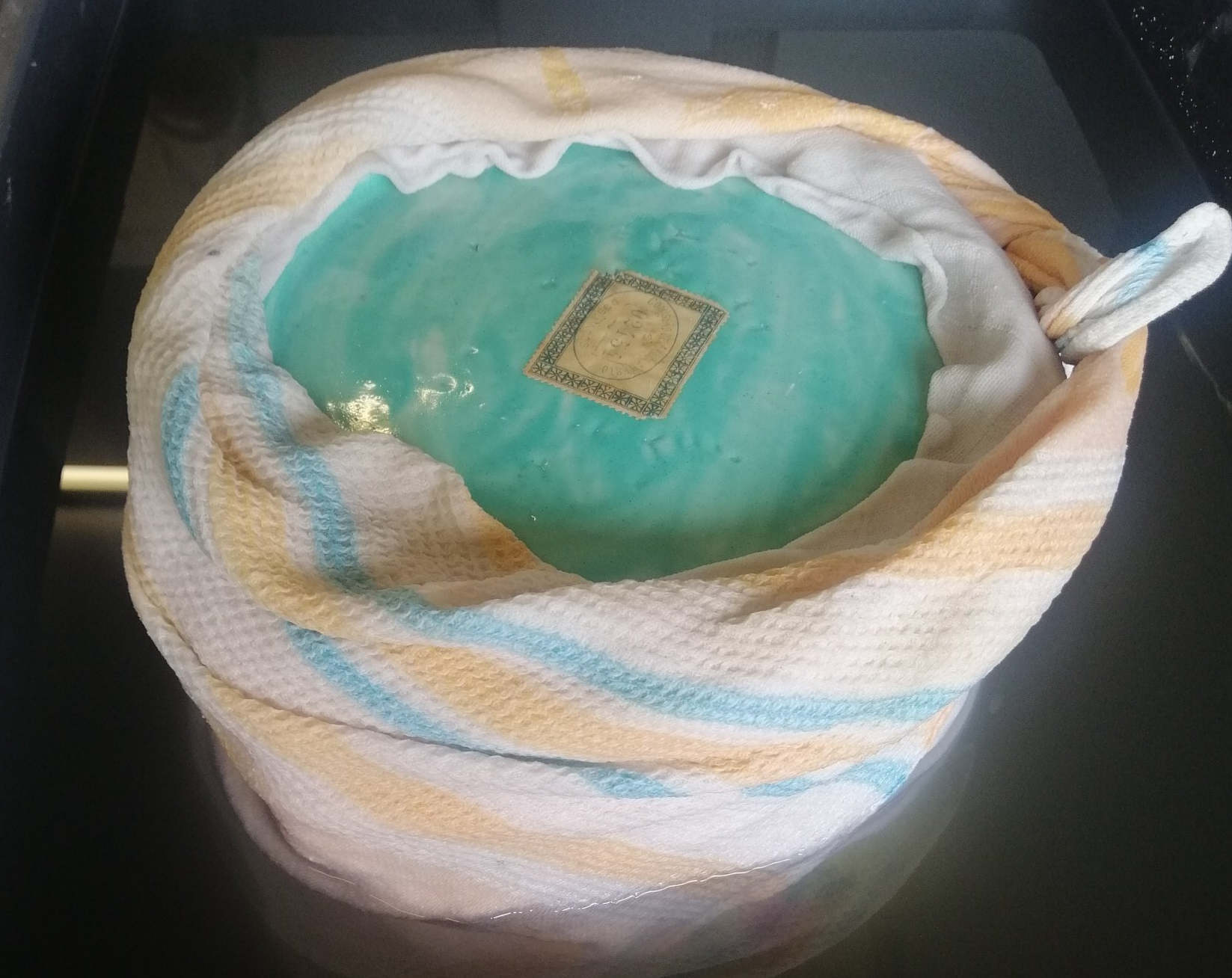 Uma toalha está enrolada em uma tigela de líquido azul