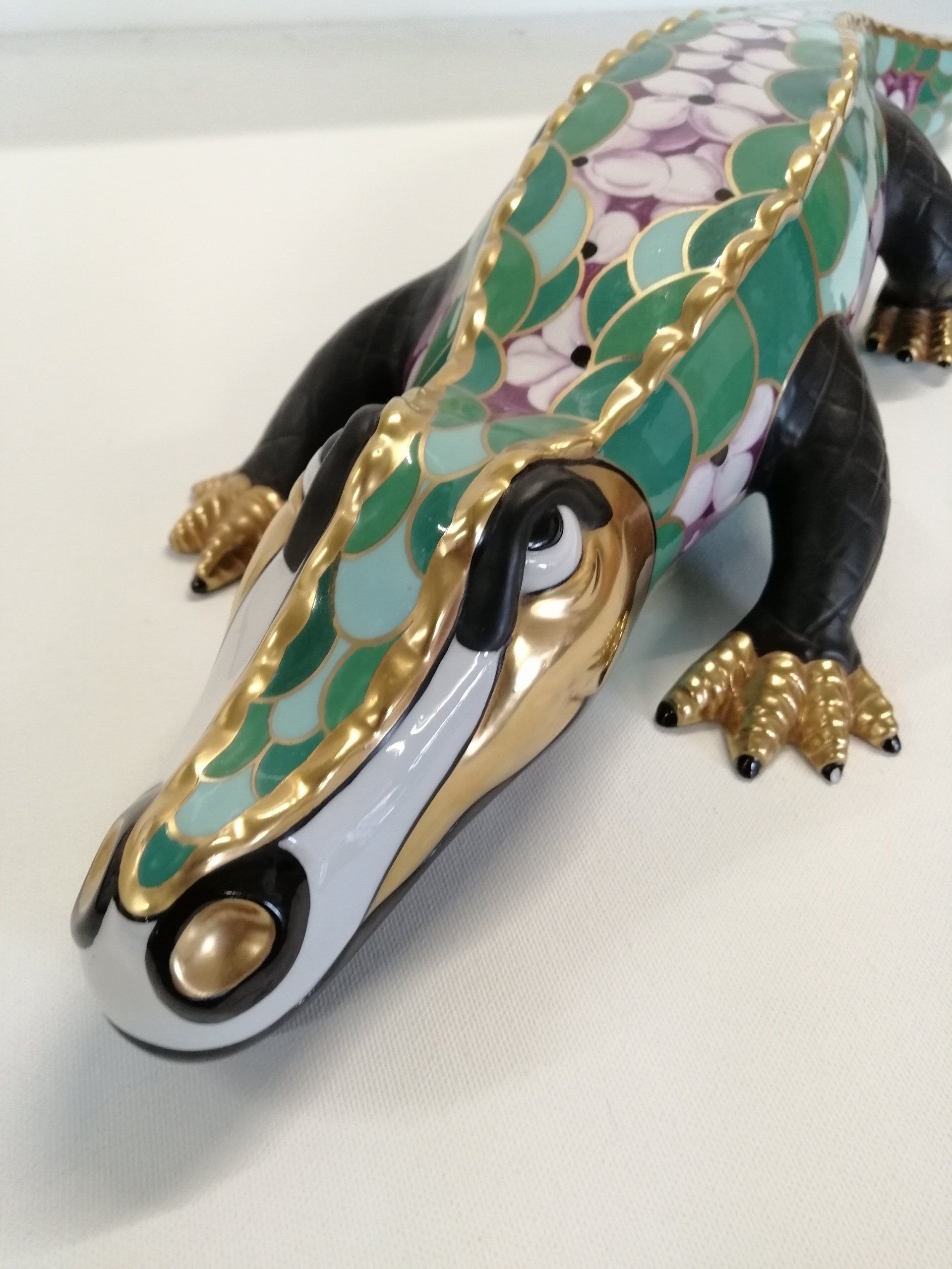 Uma estátua de um crocodilo com flores nas costas