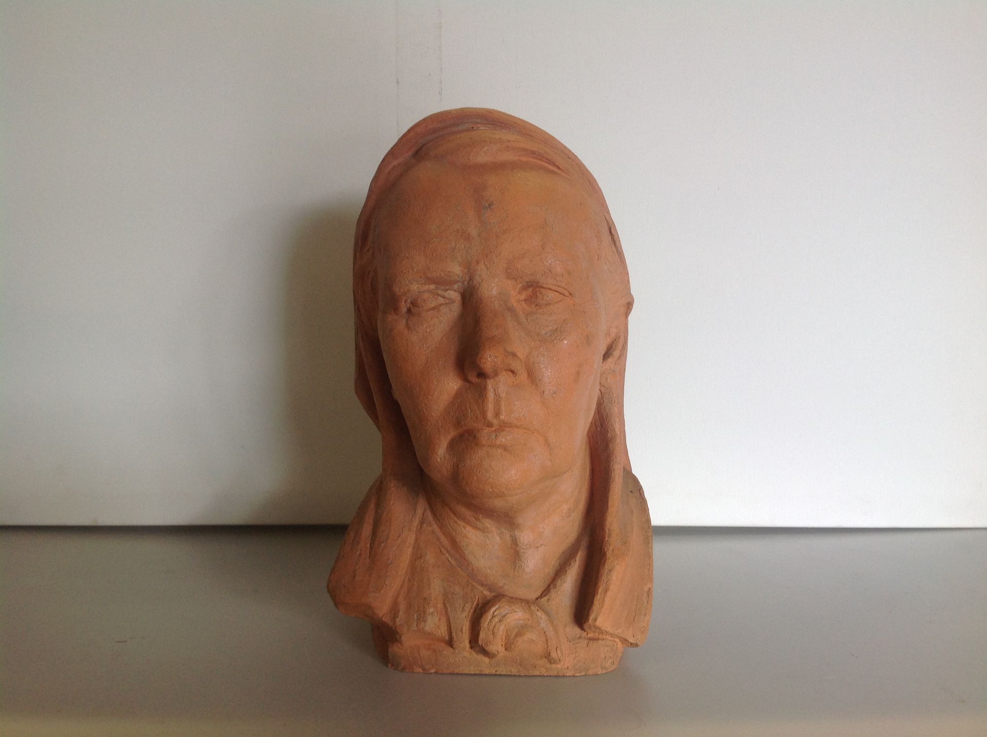 Uma estátua de uma cabeça de mulher está sentada sobre uma mesa