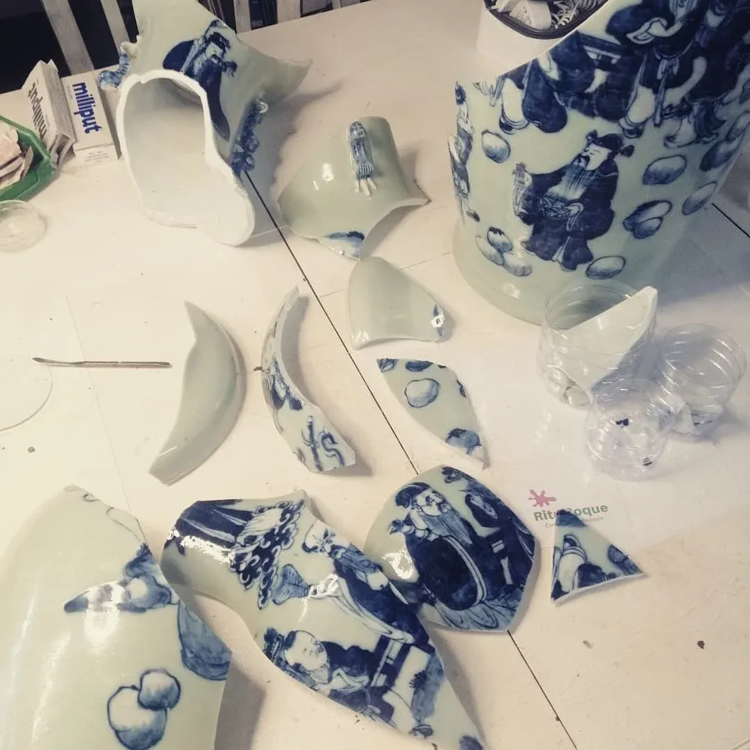 um vaso azul e branco quebrado está sobre uma mesa