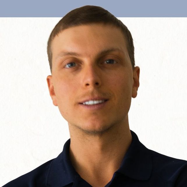 a man in a blue shirt is smiling for the camera