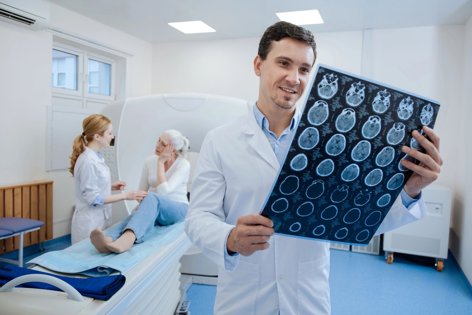 Un médico realiza una tomografía computarizada del cerebro de un paciente en una habitación de hospital.