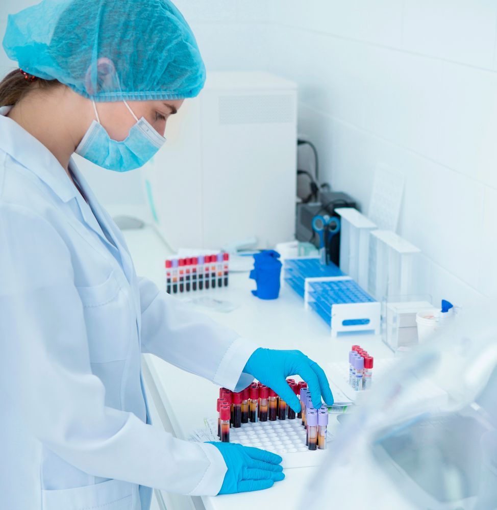 Una científica que lleva una máscara y guantes azules trabaja en un laboratorio.