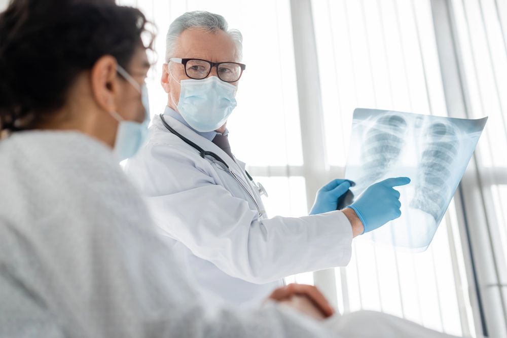 Un médico está mirando una radiografía de los pulmones de un paciente.