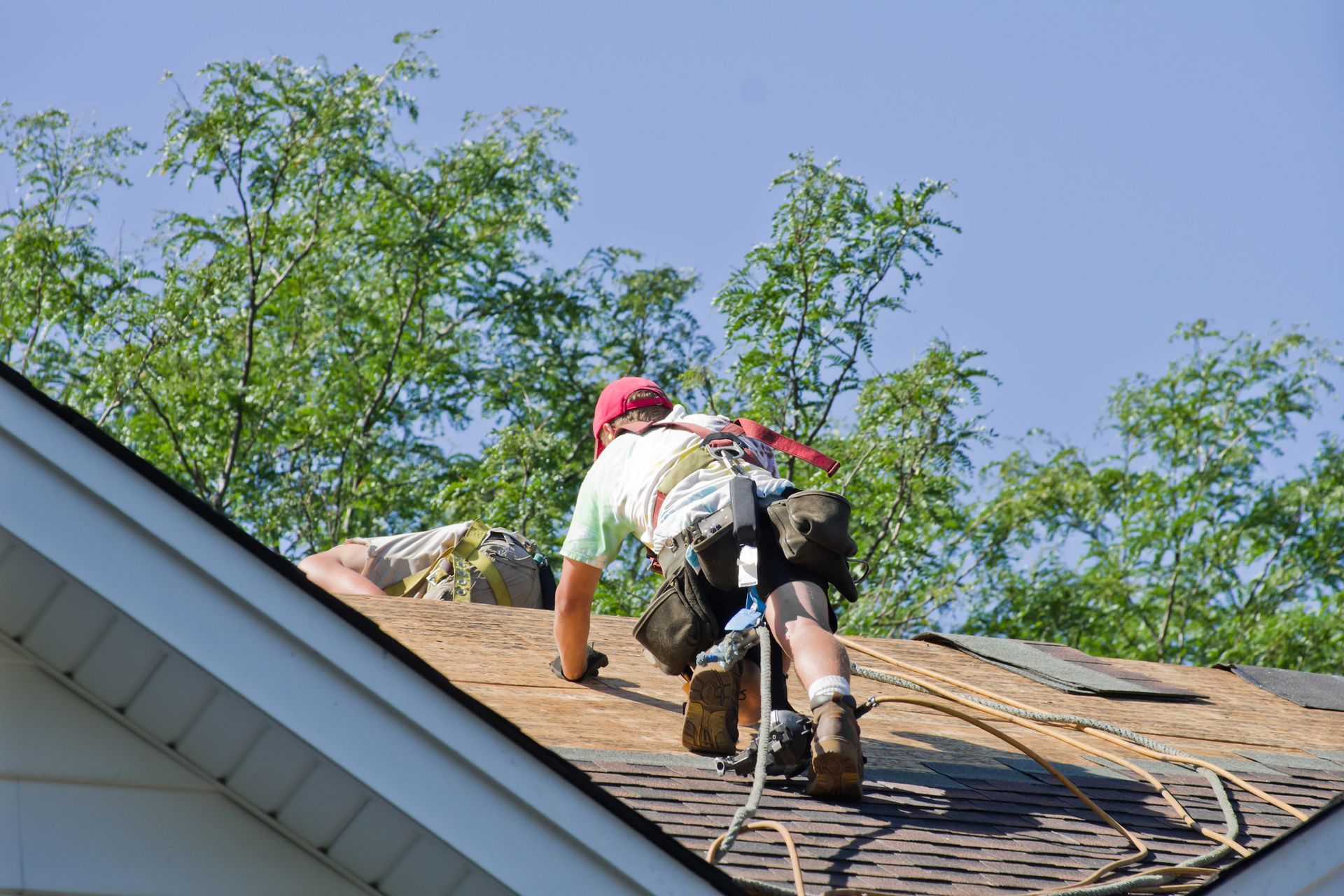 Skilled roofing contractor from DeWild Construction LLC working on a roof installation in Waukee, IA