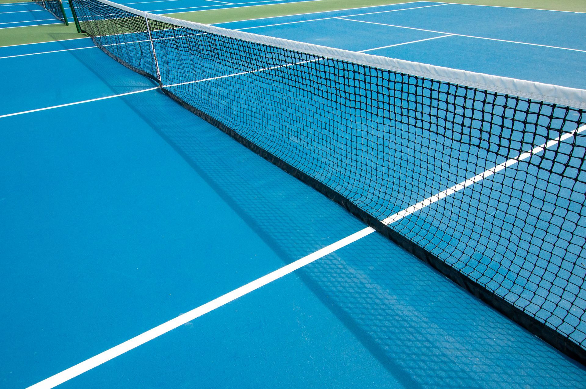 A blue and green tennis court with a white line — Staten Island, NY — Margarella Asphalt & Concrete