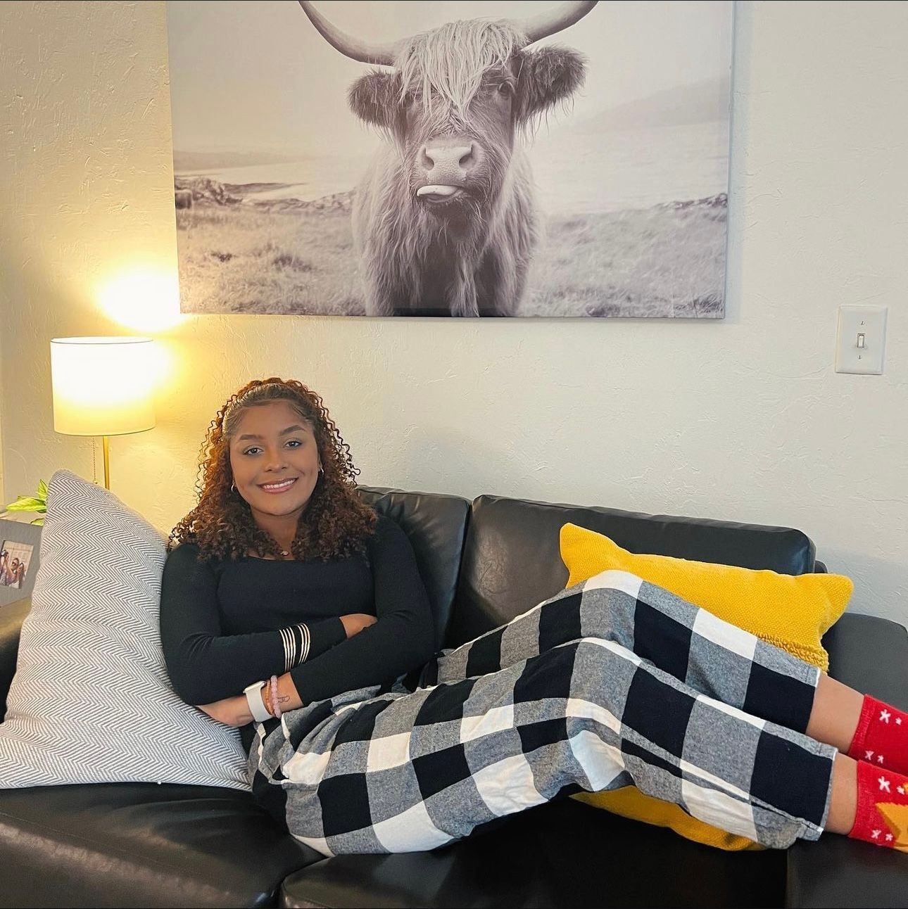 Resident relaxing on a couch in a cozy, fully furnished living room, dressed in warm, comfortable clothing at The Seasons.