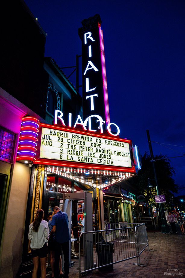 A view of the entrance to the Rialto with the marquee displaying upcoming shows and dates.