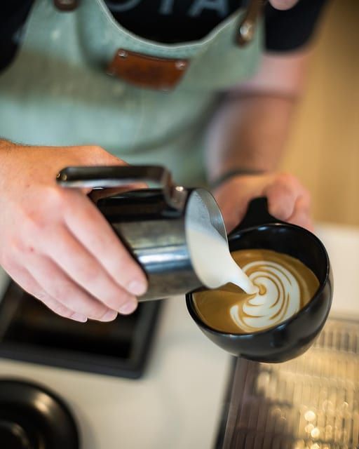 Frothed milk pouring into coffee