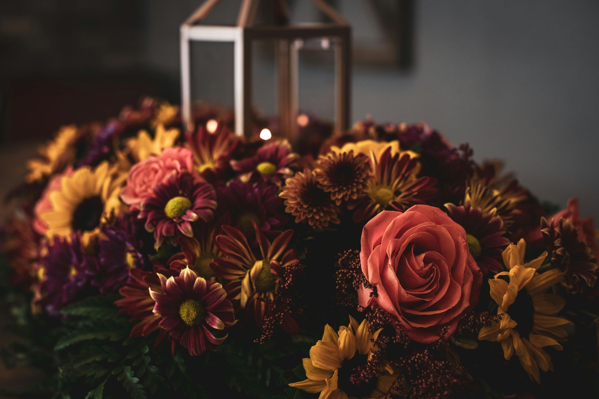 Decorate your apartment! A mix of sunflowers, roses, daisies, and carnations with a rustic candle holder.