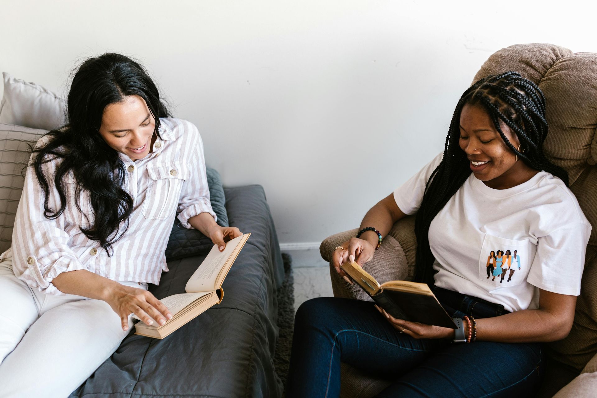 Order books right to your apartment! Two roommates are reading and smiling as they share their books with one another.