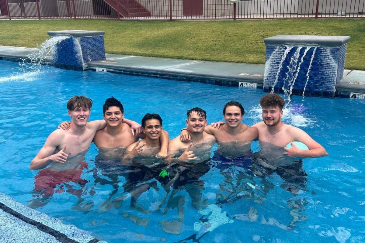 Enjoy the pool with your friends and roomies! Six male residents stand in the pool, arms around each other, smiling at the camera.