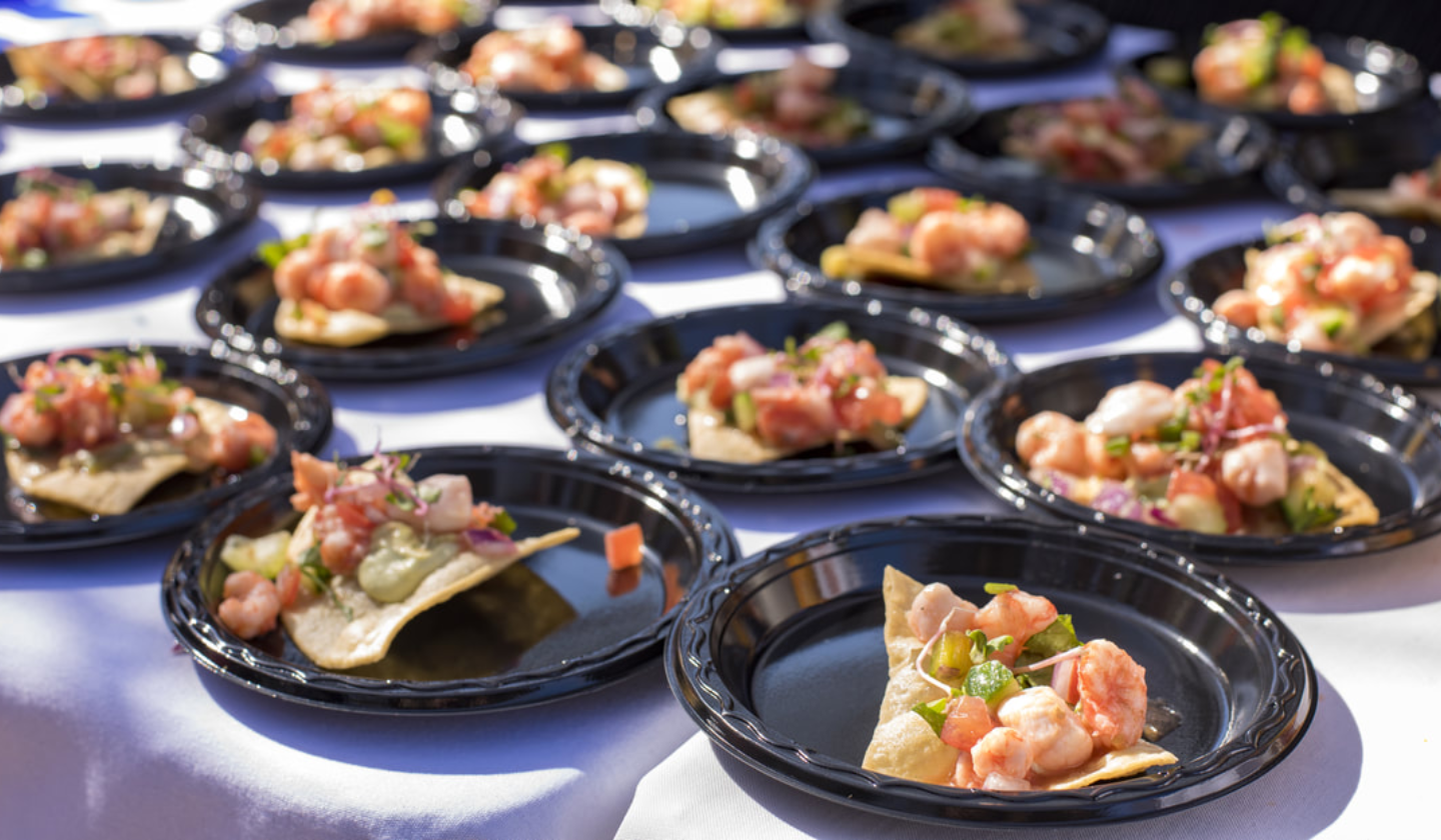 Spend a day with your Wildcat roomies at the Savor Southern Culinary Festival! A table is covered in plates with a serving of a tortilla chip with shrimp, avocado, and tomato.