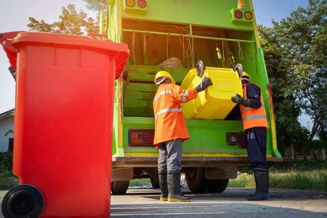 Sanitation workers emptying colourful trash bins into a truck in St. John's, Newfoundland.