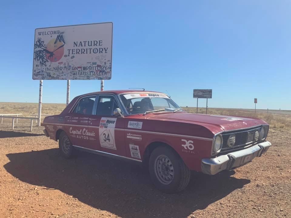 A Red Car Is Parked In Front Of A Billboard That Says Nature Territory — Queanbeyan Diesel Service In Queanbeyan, East NSW