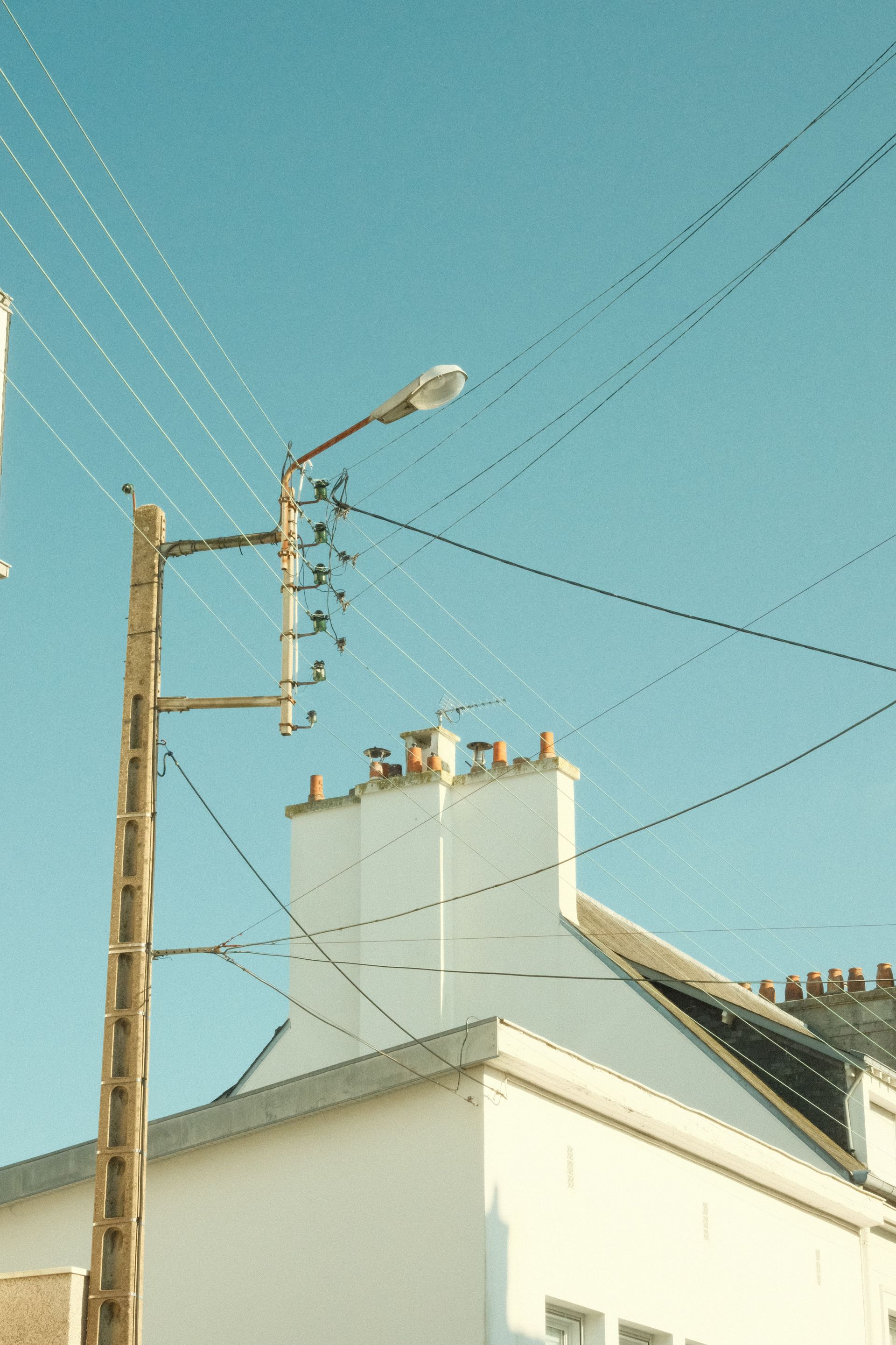 Utility workers in yellow hard hats repairing power lines from bucket trucks
