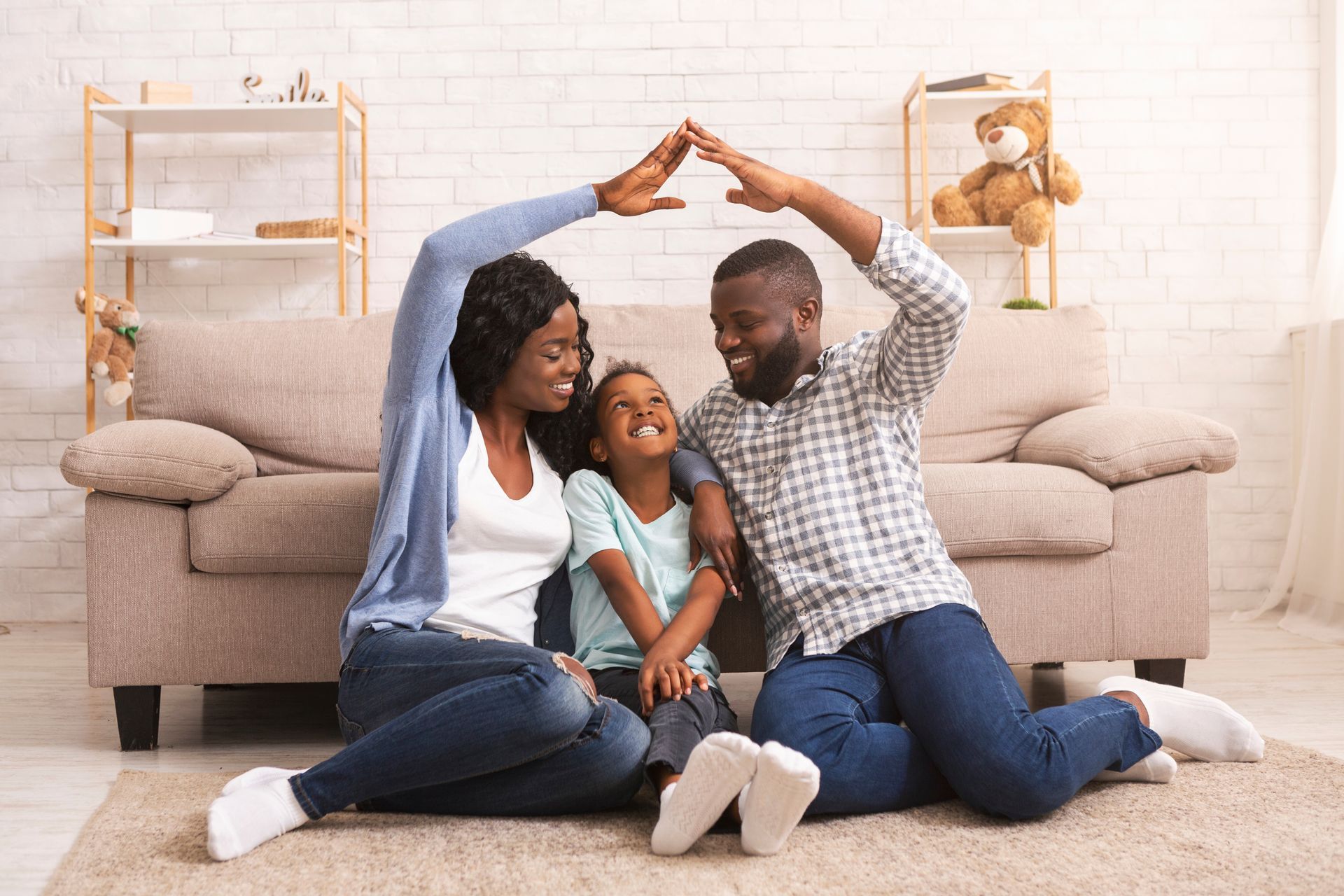 Parents making a symbolic roof of hands above their daughter's head, showcasing home insurance.