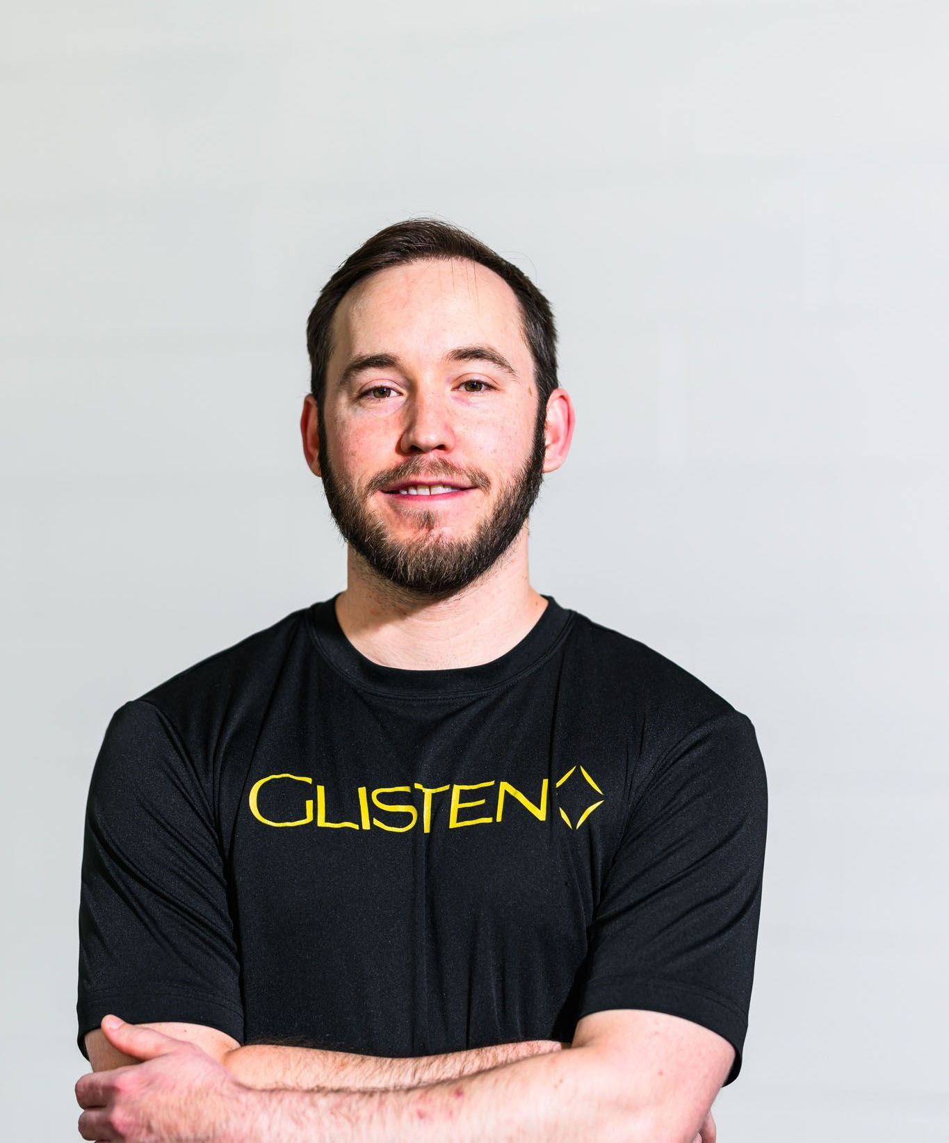 Man with beard and crossed arms wearing a black t-shirt with