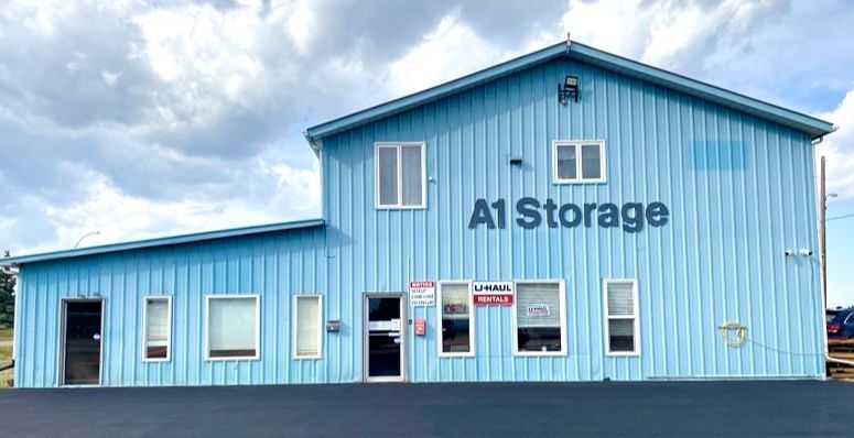 Blue self-storage building with “A1 Storage” sign under a cloudy sky