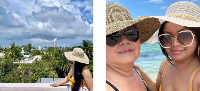 Two women in sun hats and sunglasses taking a selfie with a tropical garden and cloudy sky behind them.