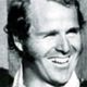 Black-and-white portrait of a smiling man in a suit jacket