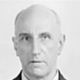 Black-and-white headshot of a bald man facing forward against a plain background