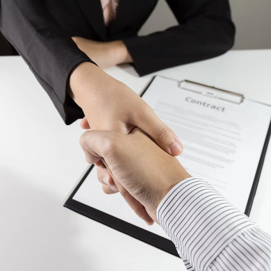 Handshake over a contract document on a desk