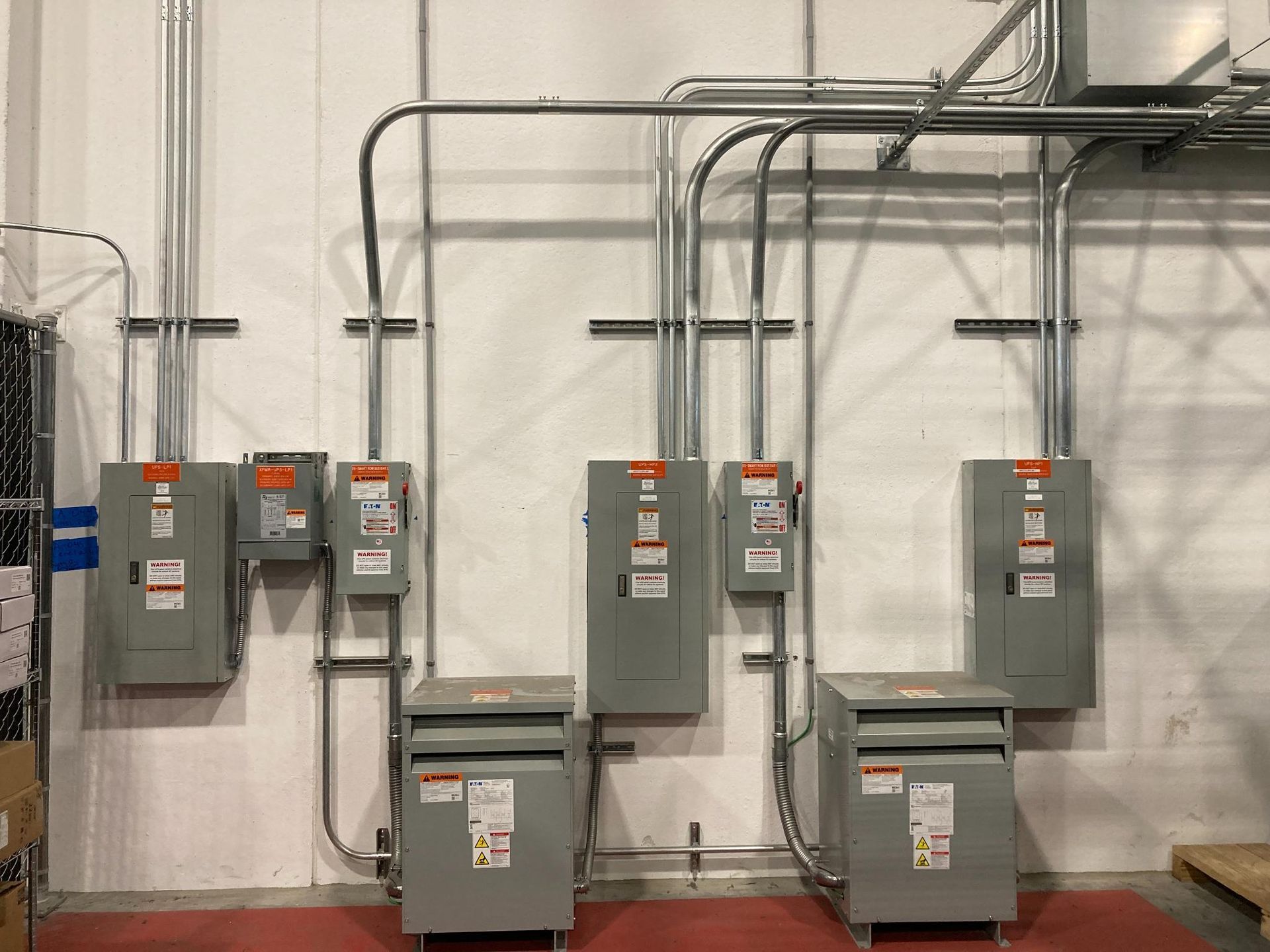 Wall-mounted electrical panels and conduit in an industrial utility room