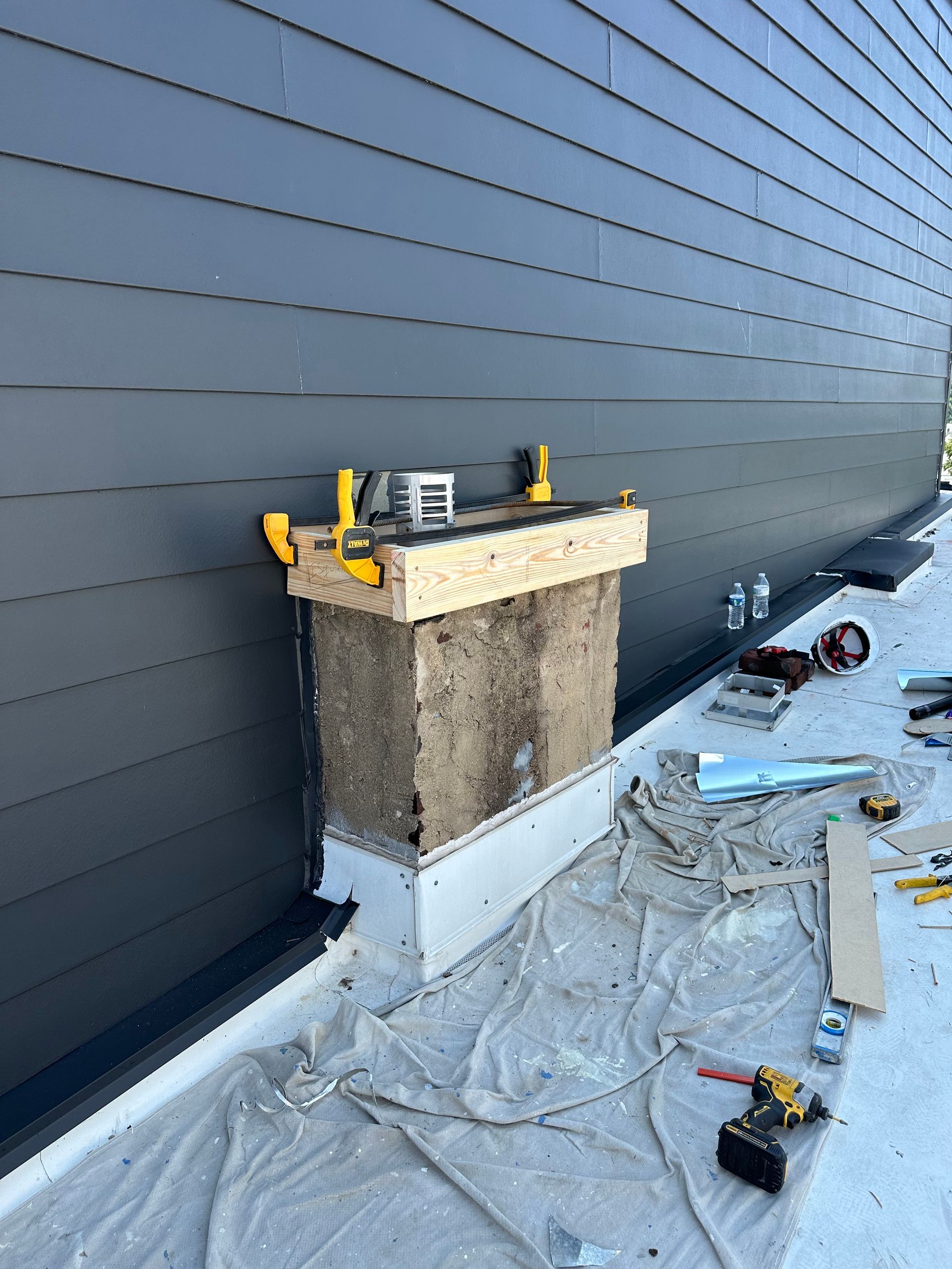 A chimney sitting next to wall is being expanded.