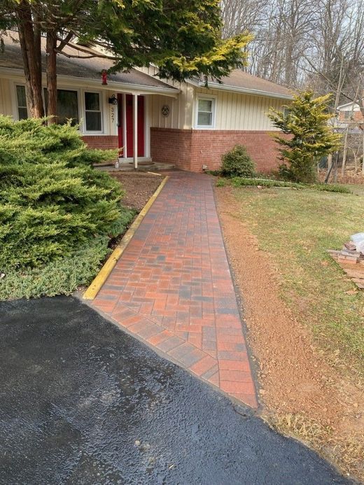 A brick walkway leading to the front door of a house.