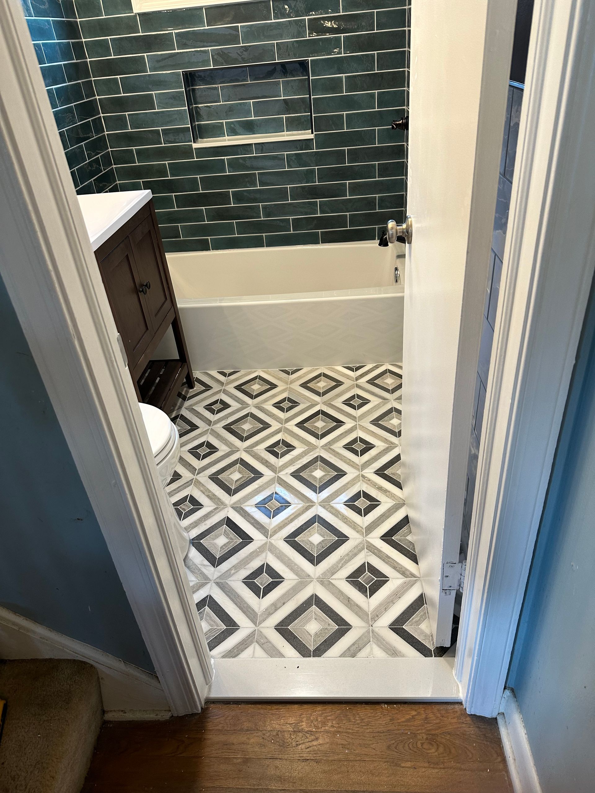 A bathroom with a bathtub with a tile floor.
