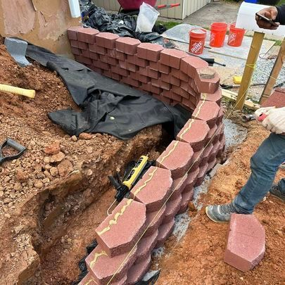 A man is working on a retaining wall
