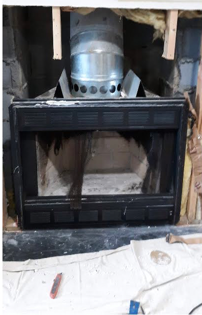 A fireplace with a metal pipe coming out of it