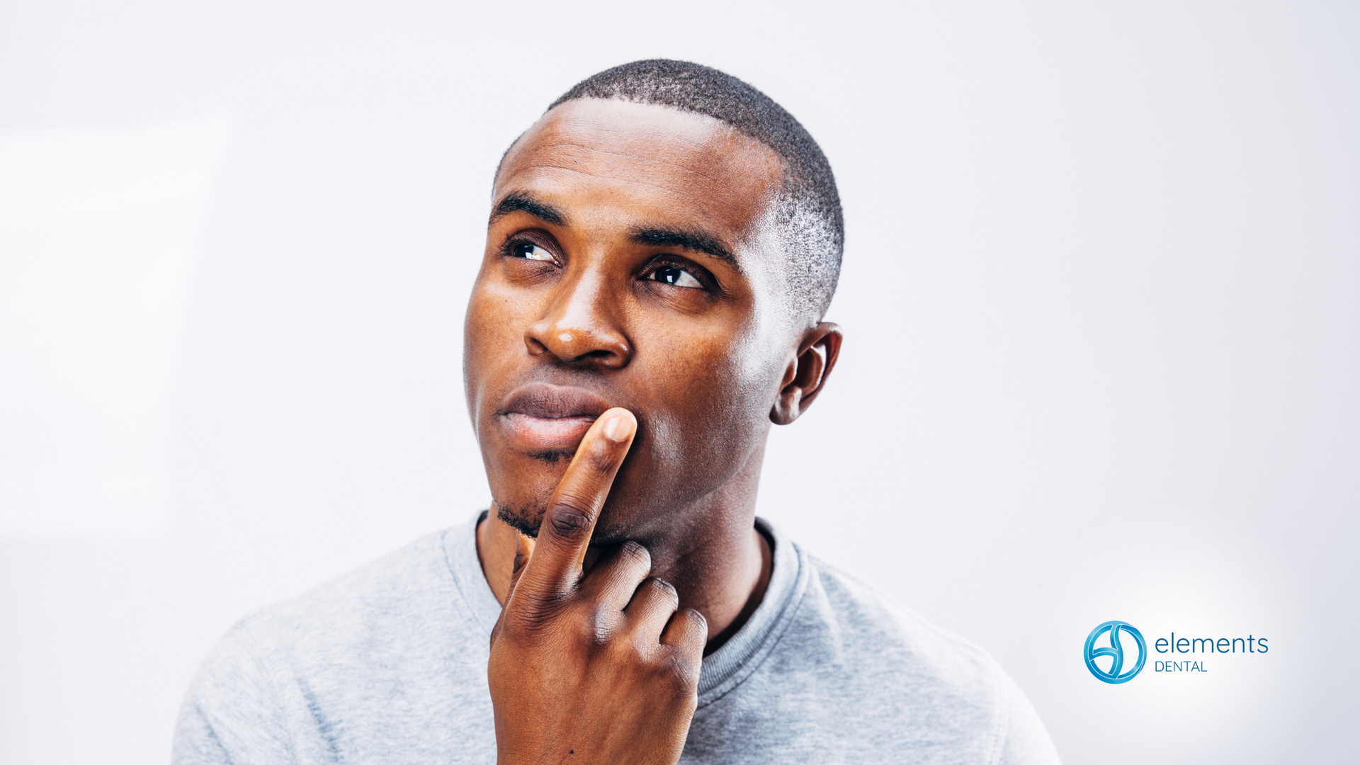 A man is thinking with his hand on his chin.