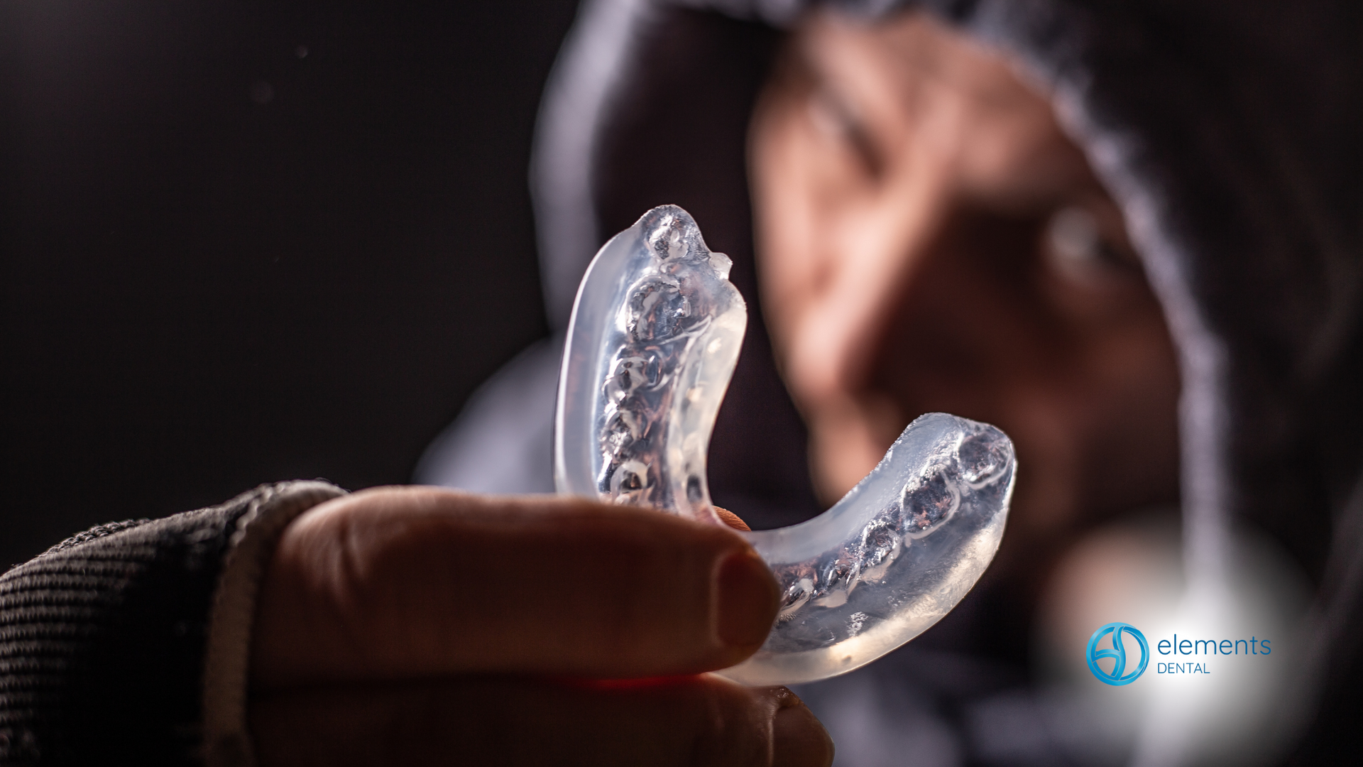 A person is holding a mouth guard in their hand.
