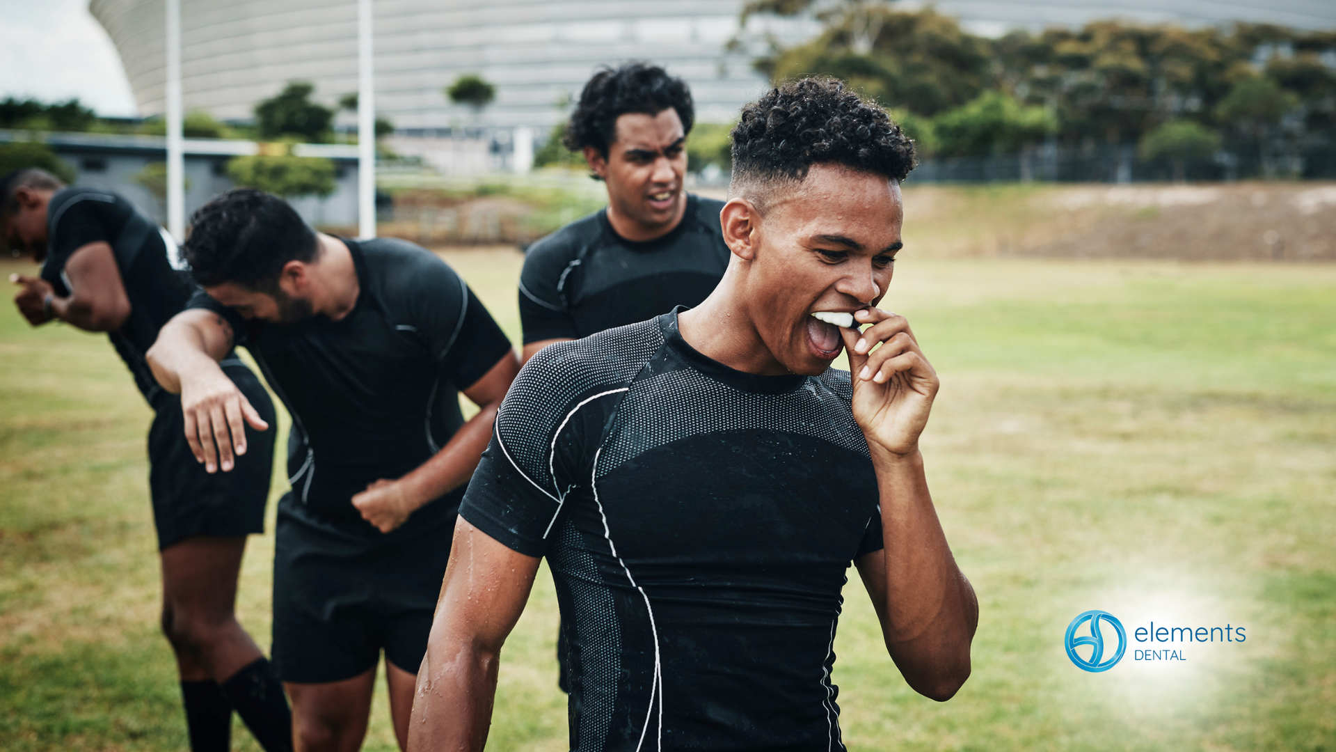 A group of men are playing rugby on a field.