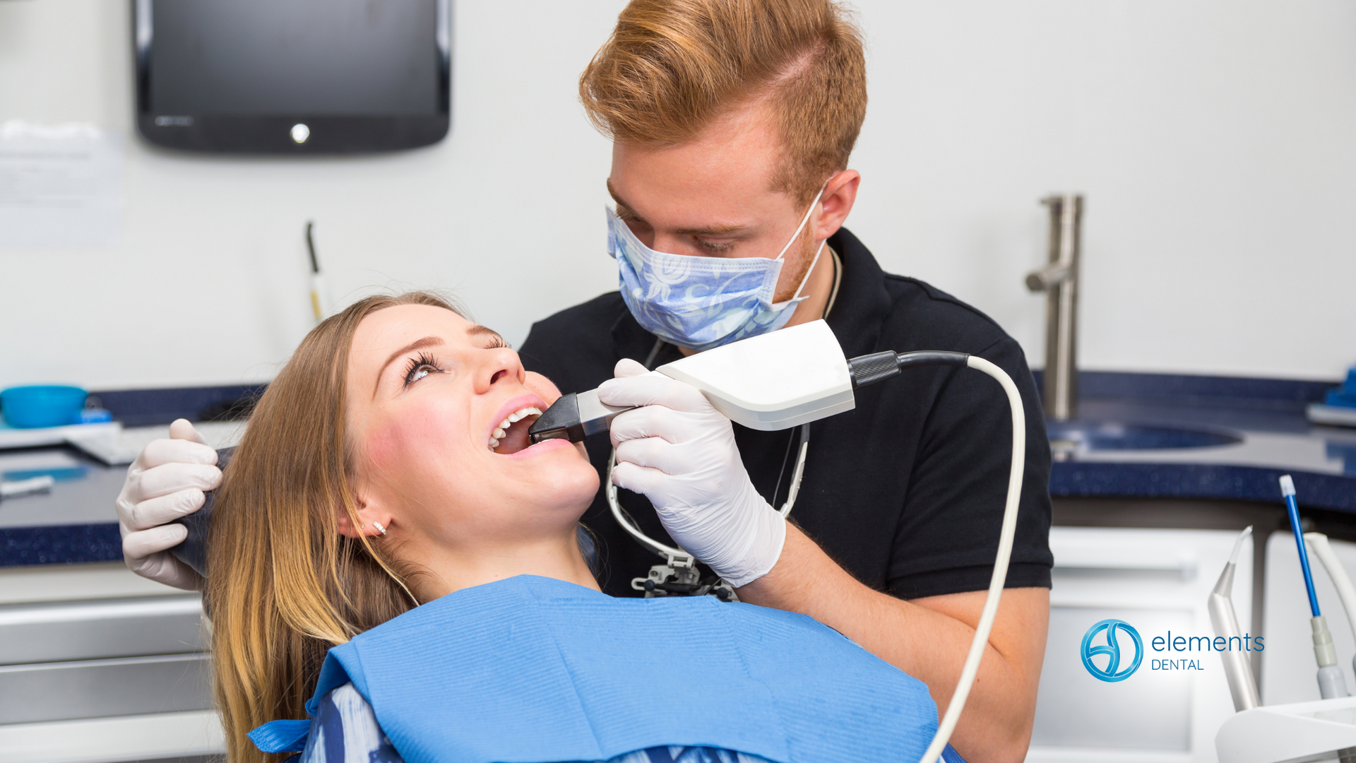 A woman is sitting in a dental chair while a dentist takes a picture of her teeth.