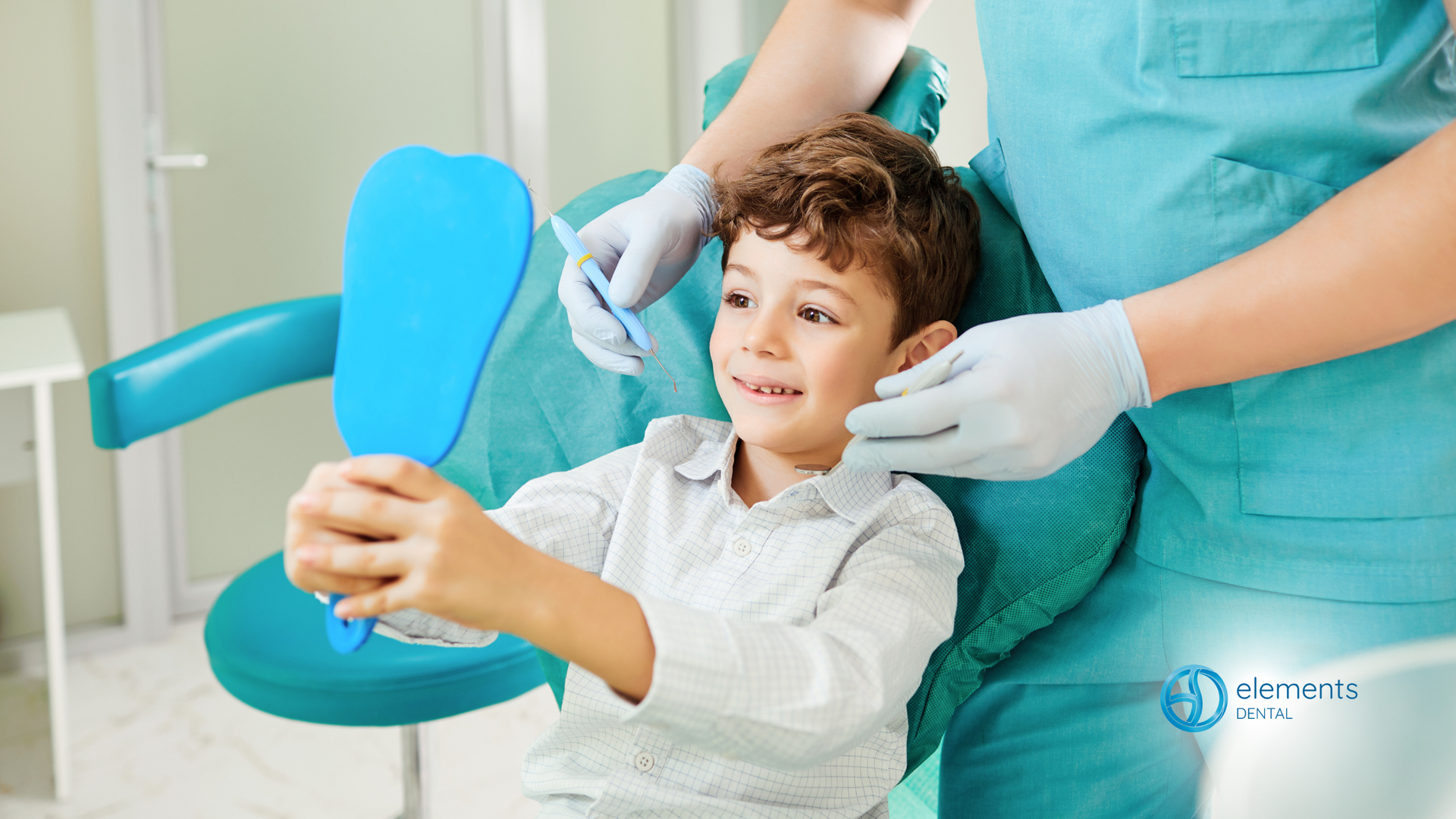 A young boy is sitting in a dental chair looking at his teeth in a mirror.
