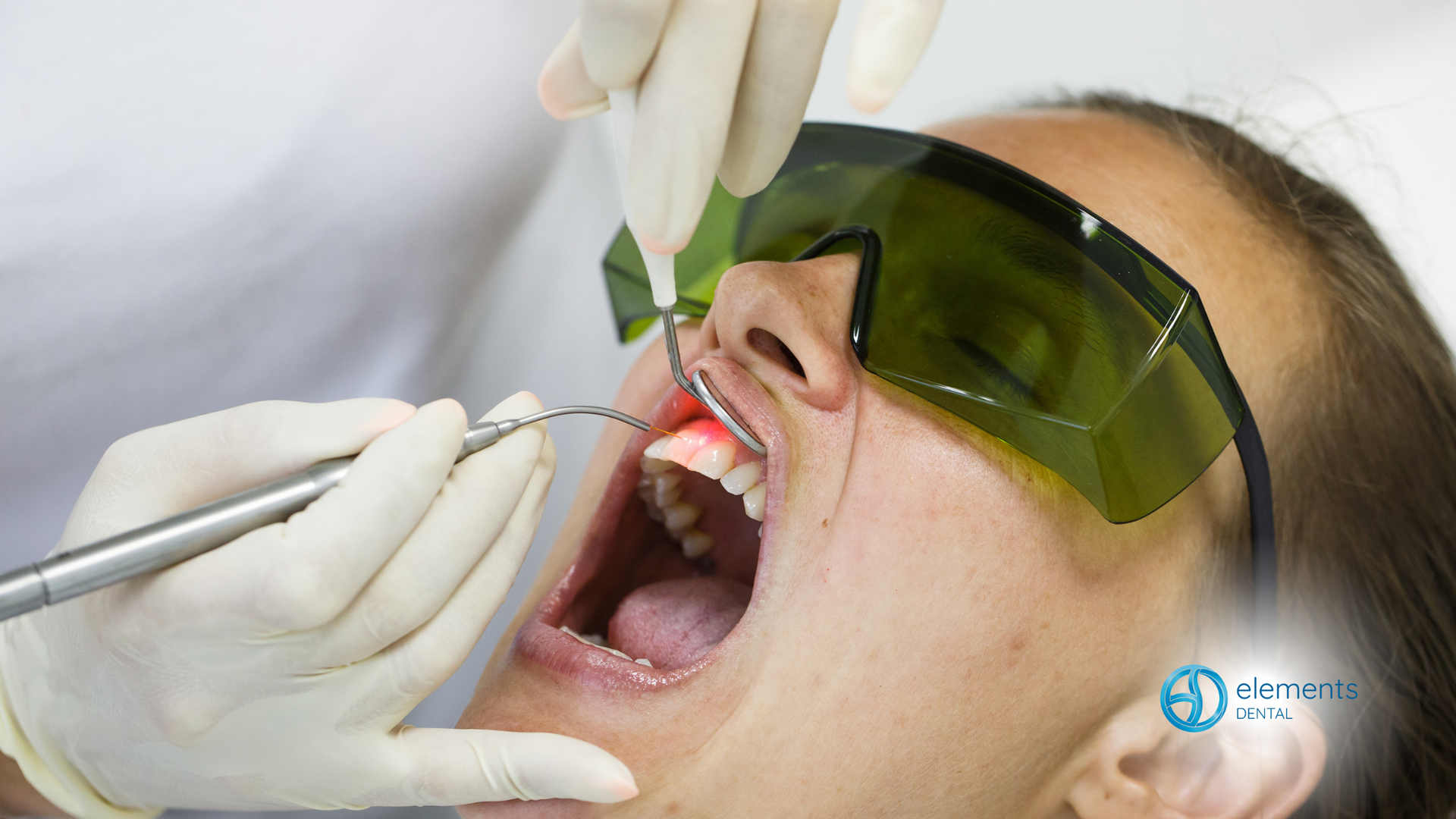 A woman is getting her teeth examined by a dentist.