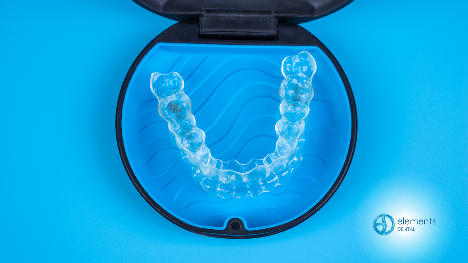 A pair of clear braces in a case on a blue surface.