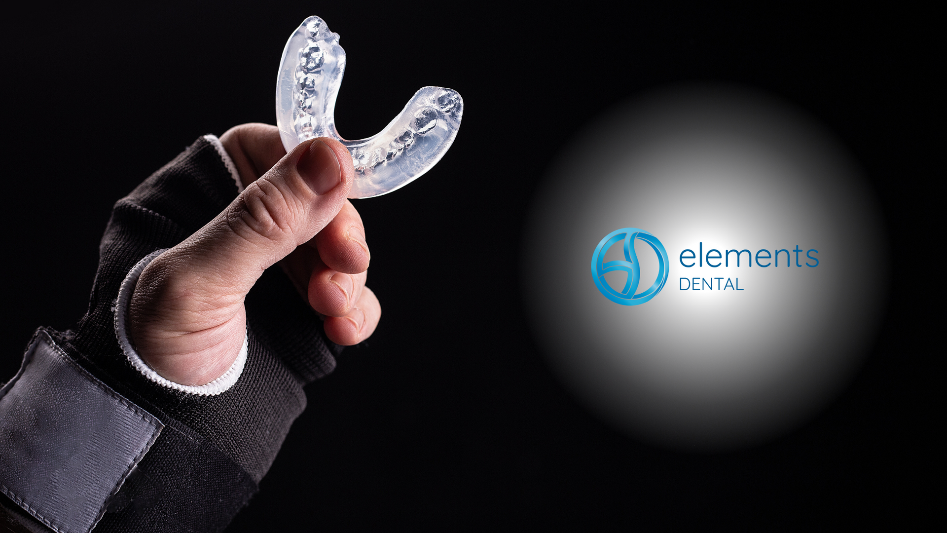 A person is holding a clear mouth guard in their hand.