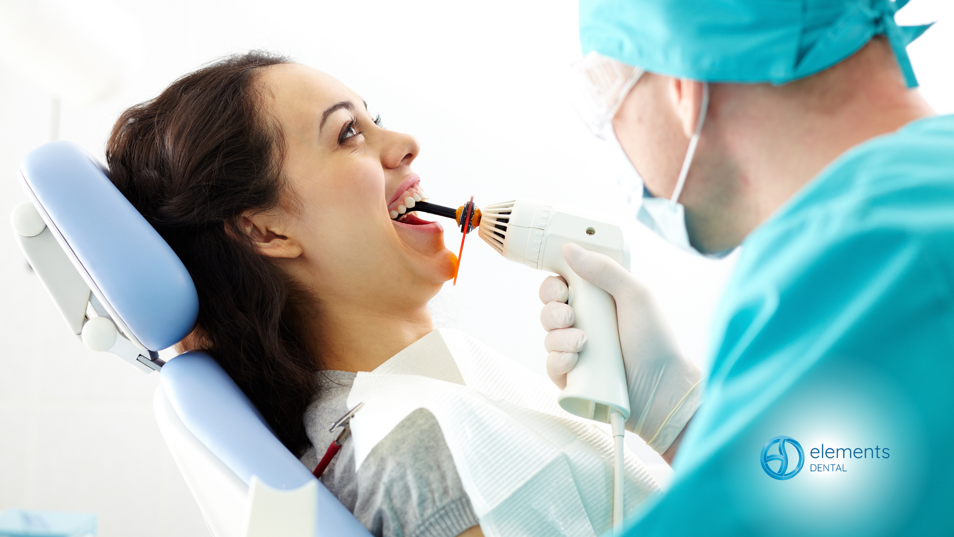 A woman is sitting in a dental chair getting her teeth examined by a dentist.