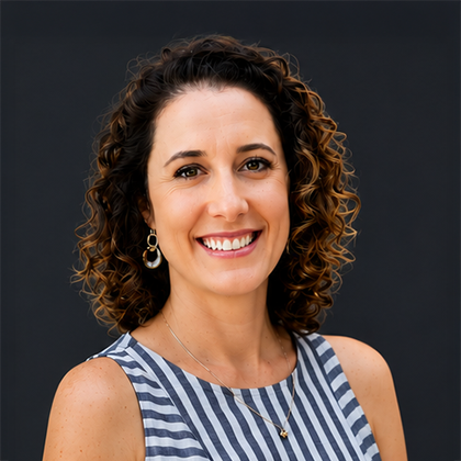 Smiling woman with curly hair in a striped sleeveless top against a dark background