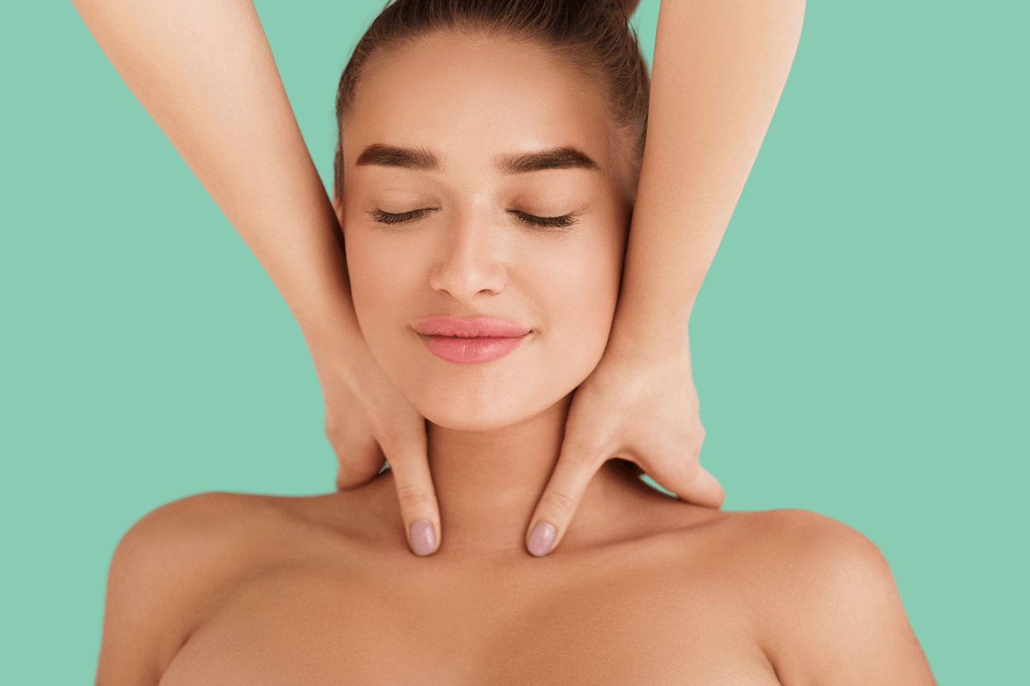 A woman is getting a massage on her neck and face.