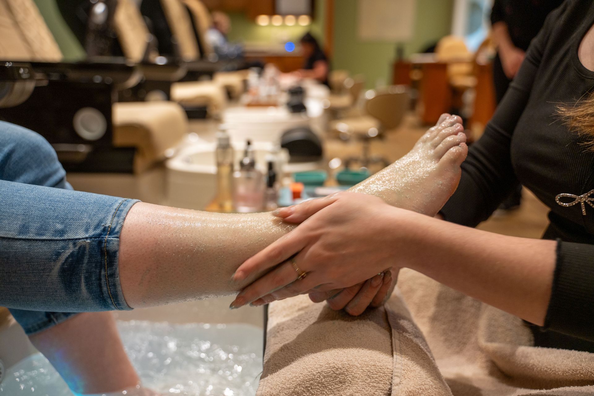 Person getting a foot spa massage while feet rest in a bowl of water and foam