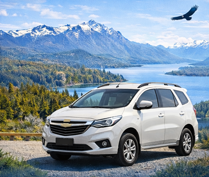 SUV blanco estacionado con vista a un lago y montañas, con un águila volando en el cielo.