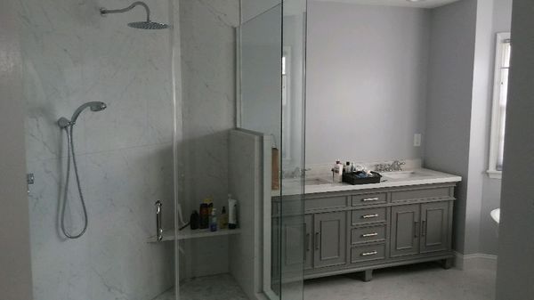 Modern bathroom with glass shower, large vanity, and neutral gray walls