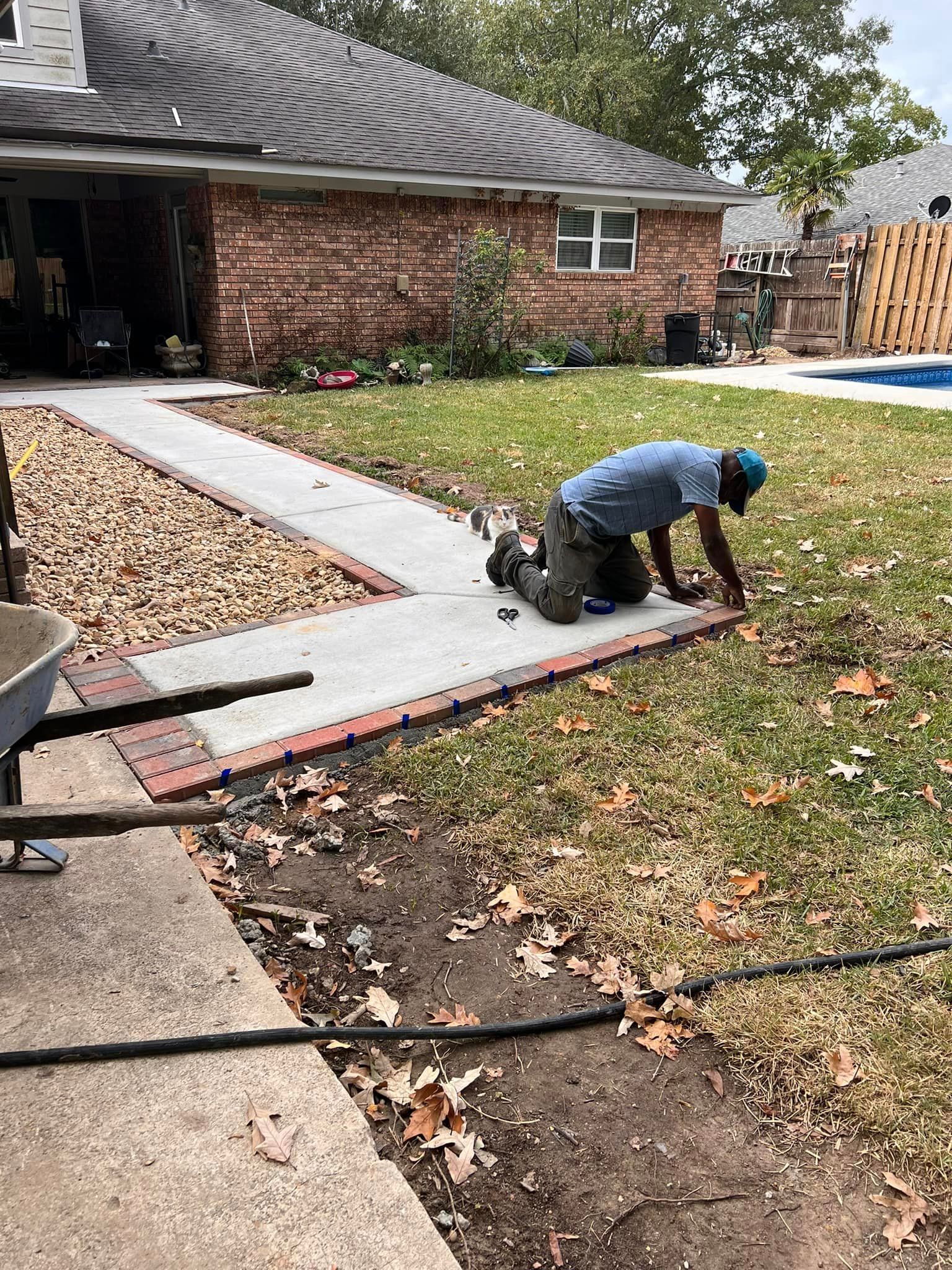 A man is kneeling on the ground in front of a house.