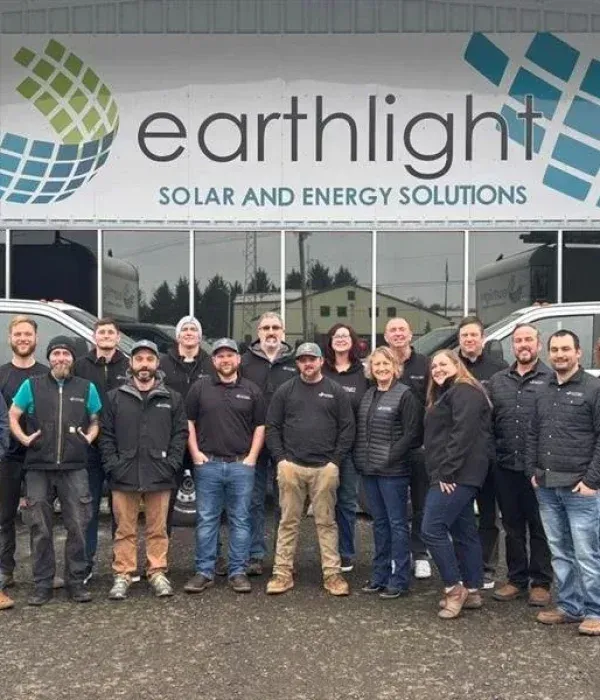 Earthlight Solar and Energy Solutions team posing outside office building under company sign
